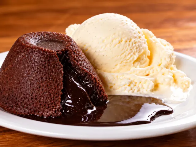 Bolo quente de chocolate com recheio cremoso e uma bola de sorvete de creme